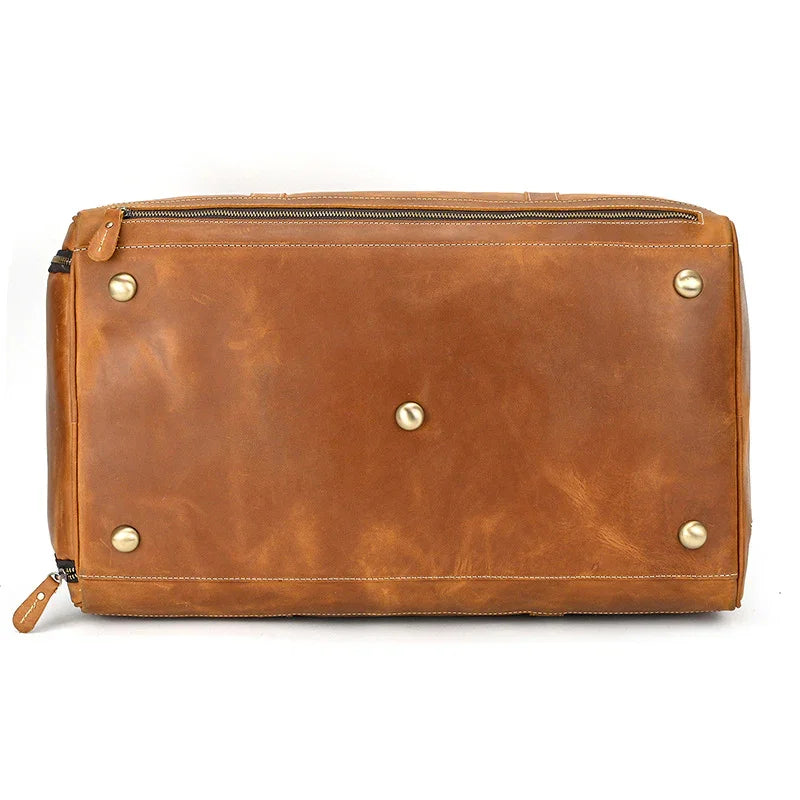 Bottom view of a large handmade full grain leather duffle bag with brass feet and zipper