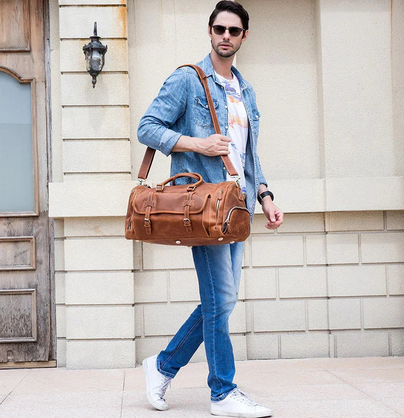 Man carrying a handmade full grain leather duffle bag with shoe compartment, casual outfit
