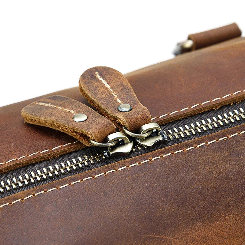 Close-up of brown full grain leather duffle bag zipper with sturdy stitching, travel bag