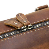 Close-up of brown full grain leather duffle bag zipper with sturdy stitching, travel bag