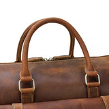 Handmade full grain leather duffle bag in dark brown with sturdy handles and visible stitching