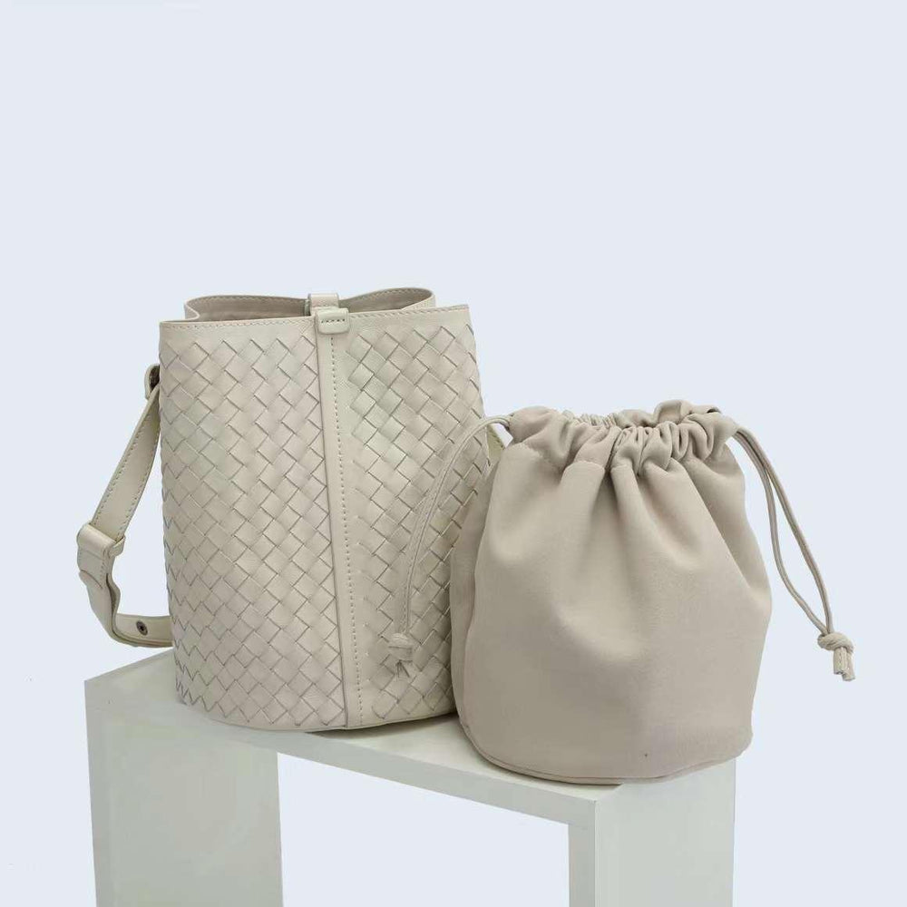 Cream woven lambskin leather bucket bag with shoulder strap and matching drawstring pouch.