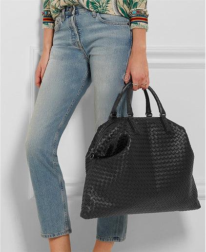 Woman holding large black intrecciato lambskin leather tote bag, quilted weave, stylish look