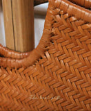 Close-up of tan cowhide leather woven handbag with bamboo-style handle