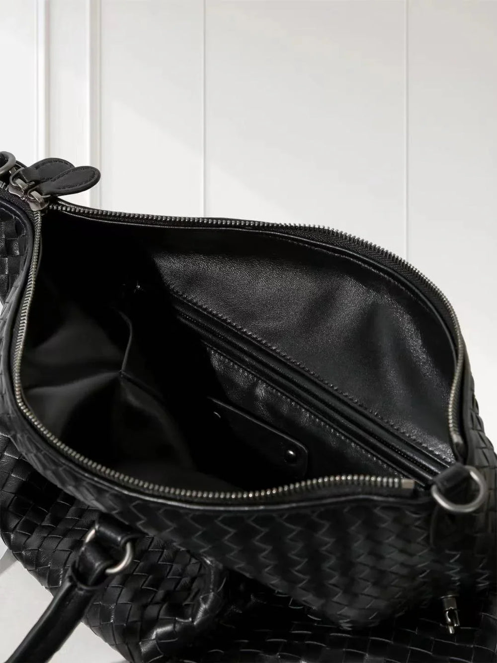 Black lambskin leather tote bag with woven intrecciato design and spacious zippered interior