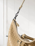 Beige woven leather tote bag with detachable strap and silver hardware against white background
