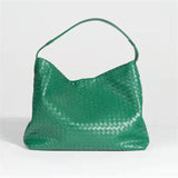 Green woven lambskin leather tote bag with a single shoulder strap on a plain background