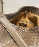 Close-up of a taupe woven lambskin leather tote bag with quilted texture and interior zip pocket