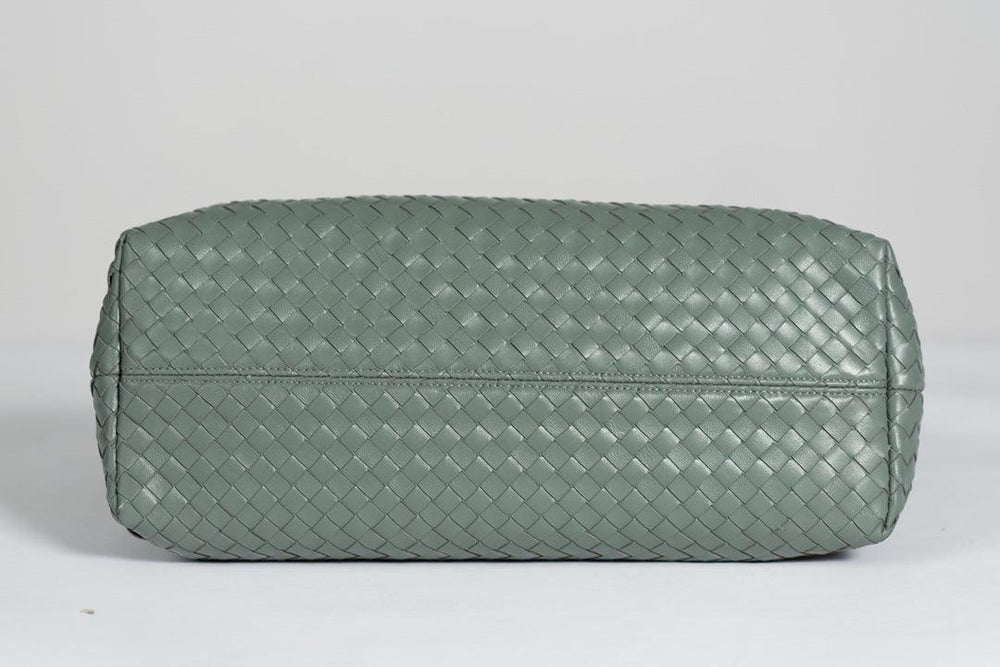 Bottom view of large green woven lambskin leather tote bag on light background