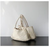 Beige woven leather hobo shoulder bags with long braided handles on black table