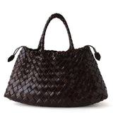 Dark brown woven leather hobo trapezoidal shoulder bag with braided handle on white background