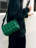 Green lambskin leather quilted shoulder bag with woven design, worn crossbody by a woman