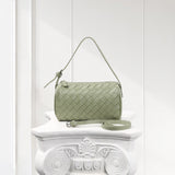 Light green woven lambskin leather mini Boston bag with detachable strap on white pedestal