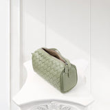 Sage green woven lambskin leather mini Boston bag with zipper on white surface