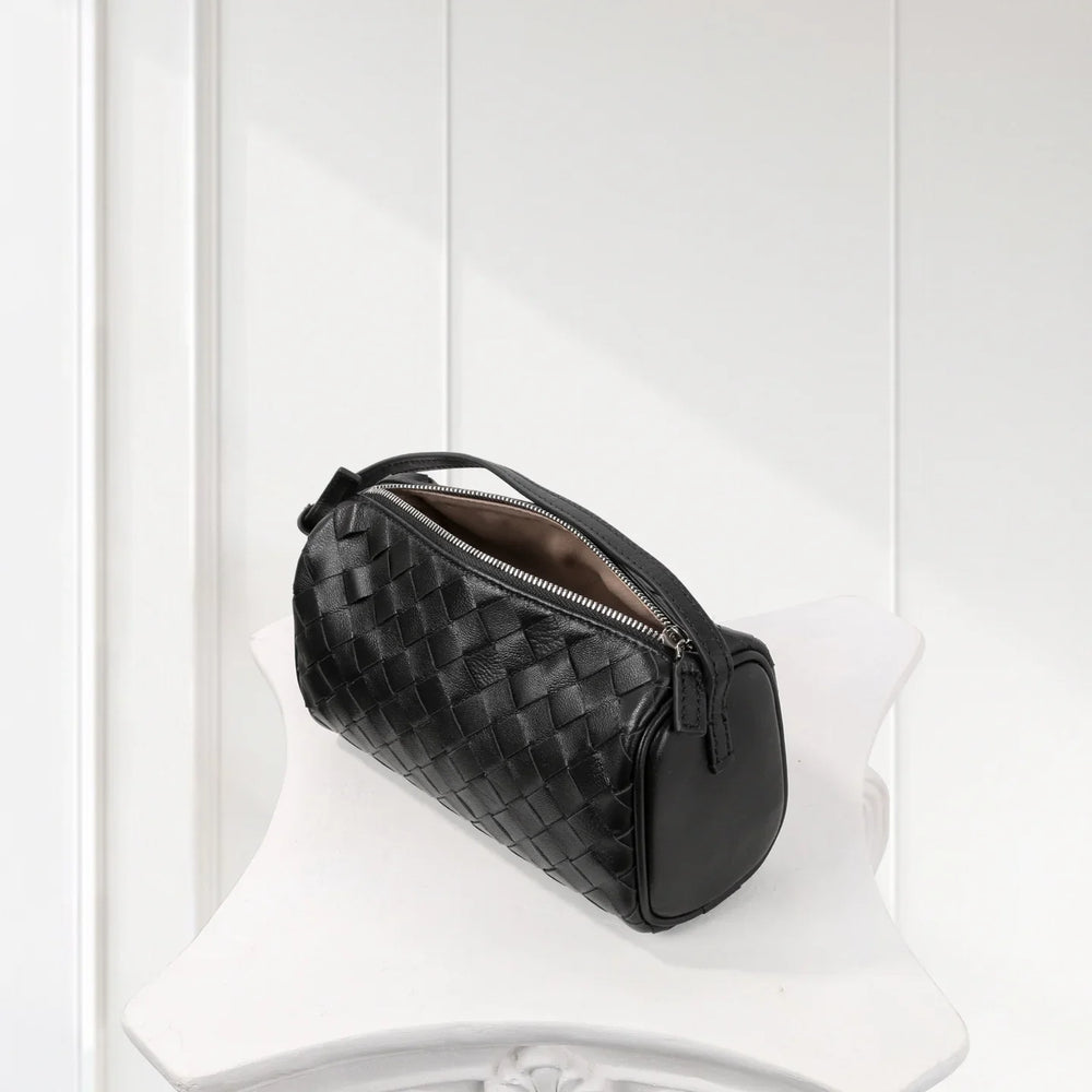 Black lambskin woven mini Boston bag with zipper, minimalist leather shoulder purse on white stand