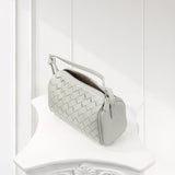 Mini woven lambskin leather crossbody bag with top handle in light grey on white pedestal.
