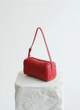 Red lambskin leather woven mini Boston bag with shoulder strap on white stone block