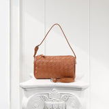 Tan lambskin leather woven mini Boston bag with detachable strap on a white pedestal