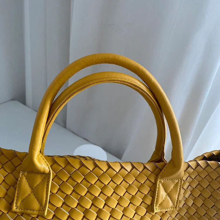 Yellow handwoven vegan leather tote bag with double handles, close-up view