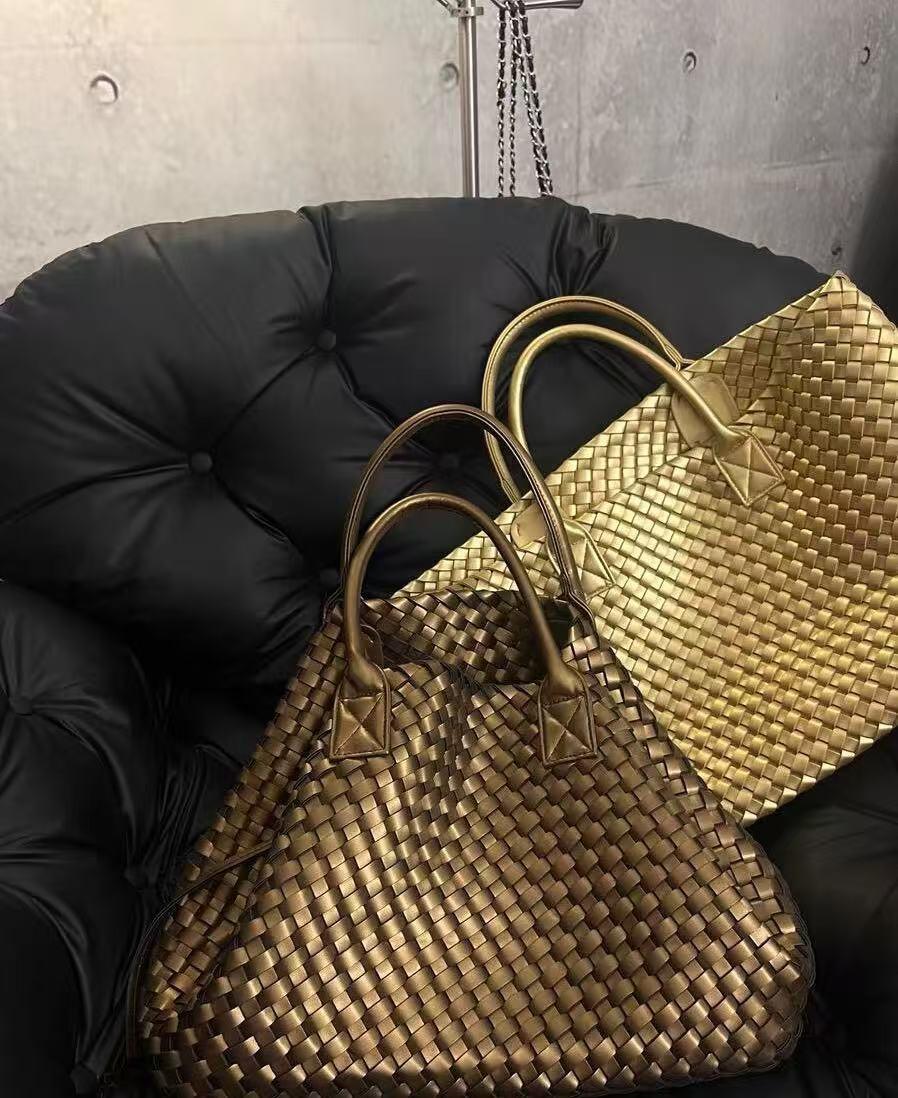 Two large handwoven vegan leather tote bags in gold and bronze on a black cushioned chair