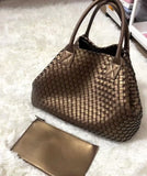 Large handwoven vegan leather tote bag with matching pouch on white fluffy rug