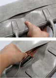 Hand showing outer pocket of grey leather laptop briefcase for women with phone inside
