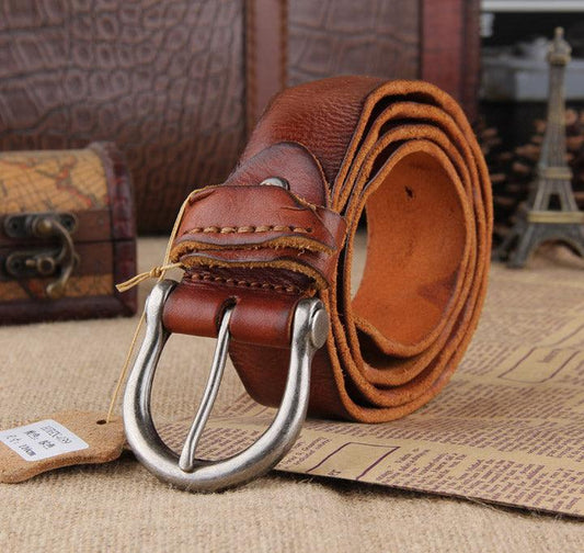 Handcrafted genuine brown leather men's belt with silver buckle on rustic background