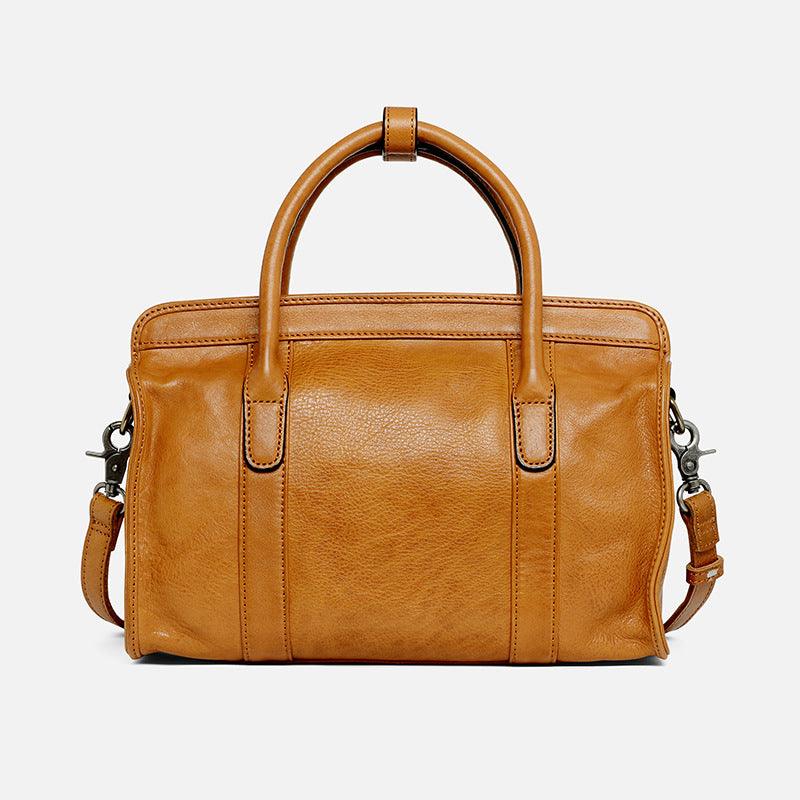 Tan leather Boston bag with top handles and detachable shoulder strap on white background