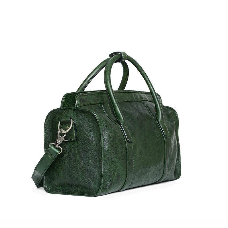 Green leather Boston bag with top handles and detachable shoulder strap on white background