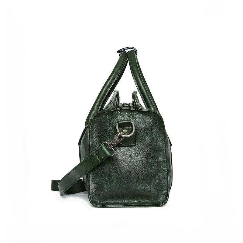 Side view of a green leather Boston bag with detachable shoulder strap and silver hardware