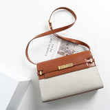 Minimalist leather and canvas crossbody bag with gold hardware on white background