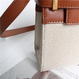 Minimalist crossbody bag with brown leather strap and beige textured fabric body