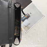 Minimalist black leather crossbody handbag open on table with floral lining visible