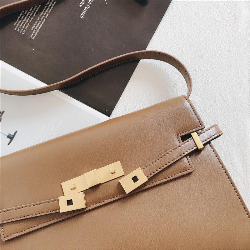 Minimalist tan leather crossbody bag with gold hardware and adjustable shoulder strap