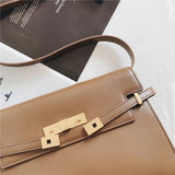 Minimalist tan leather crossbody bag with gold hardware and adjustable shoulder strap