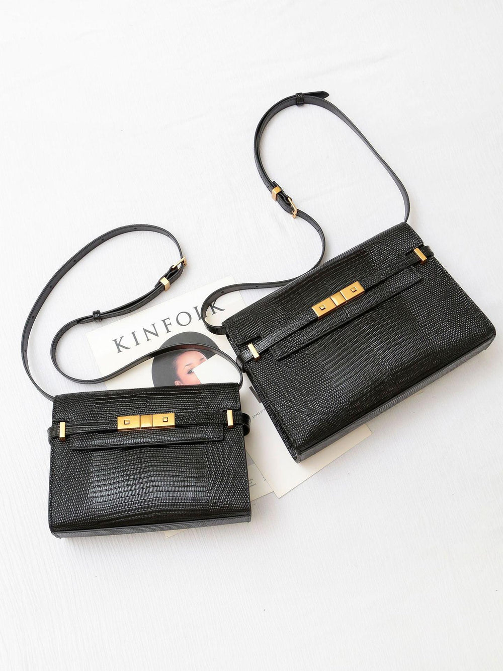 Two black leather crossbody bags with gold hardware on white background