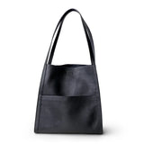 Black grain cowhide leather tote bag with minimalist design and front pocket on white background