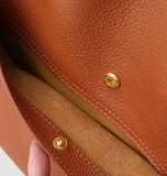 Close-up of brown grain cowhide leather tote bag interior with gold magnetic snap closure