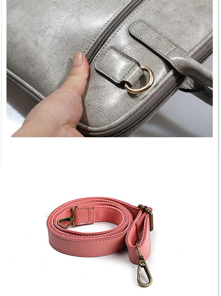 Detail of grey leather laptop bag with D-ring and detachable pink shoulder strap