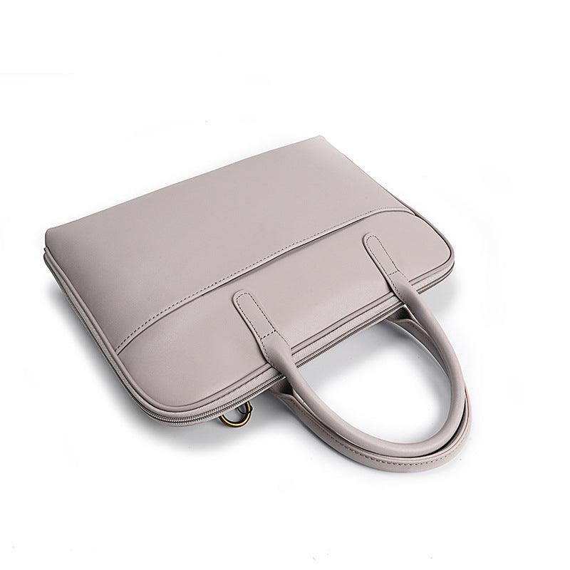 Slim light beige leather laptop bag for women with handles, fits 14 inch, on white background