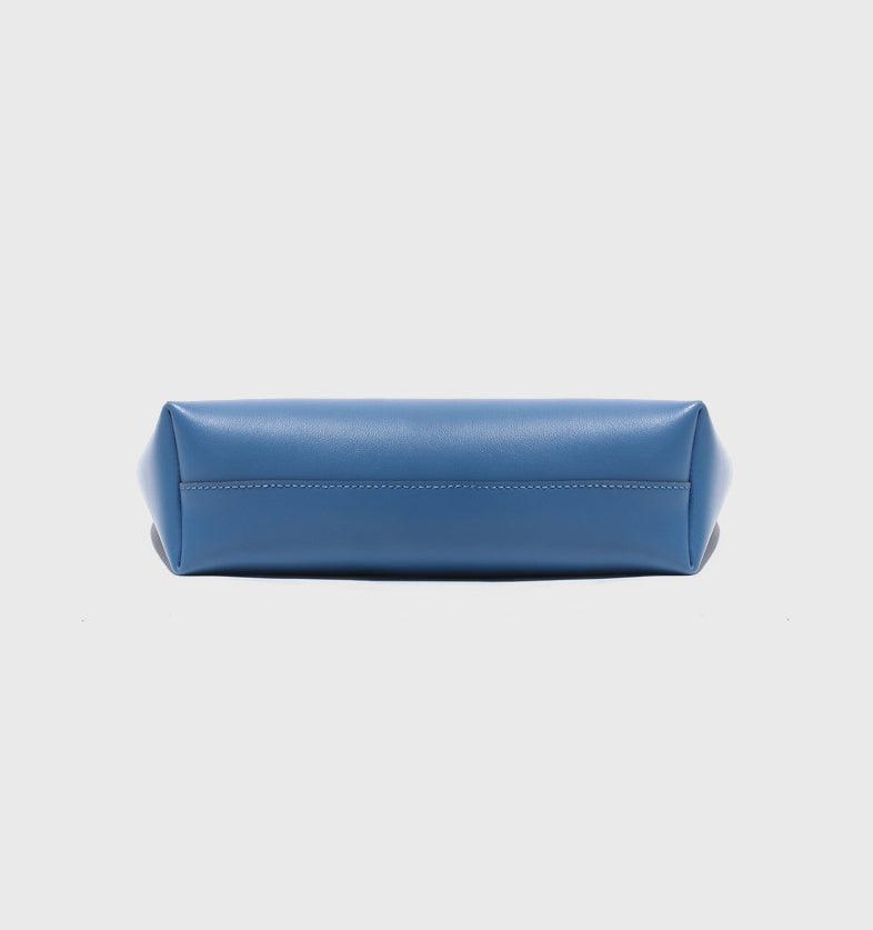 Bottom view of blue genuine leather minimalist bucket bag on white background