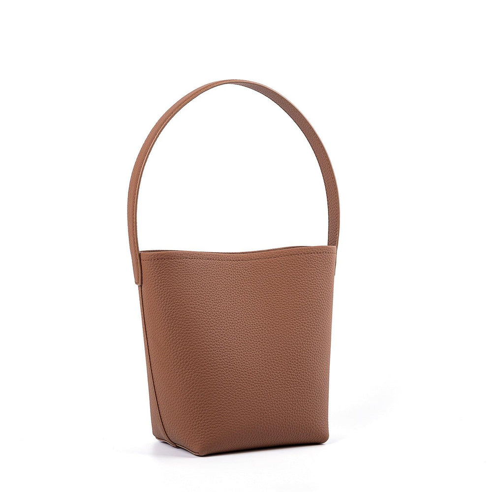 Minimalist tan leather bucket bag with top handle, large tote style on white background