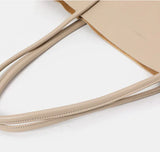 Minimalist beige genuine leather tote bag with soft double top handles on white background