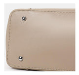 Beige genuine leather tote bag bottom with metal feet and detailed stitching