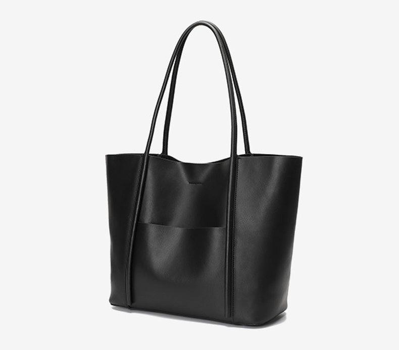 Minimalist black genuine leather tote handbag with top handles and front pocket on white background
