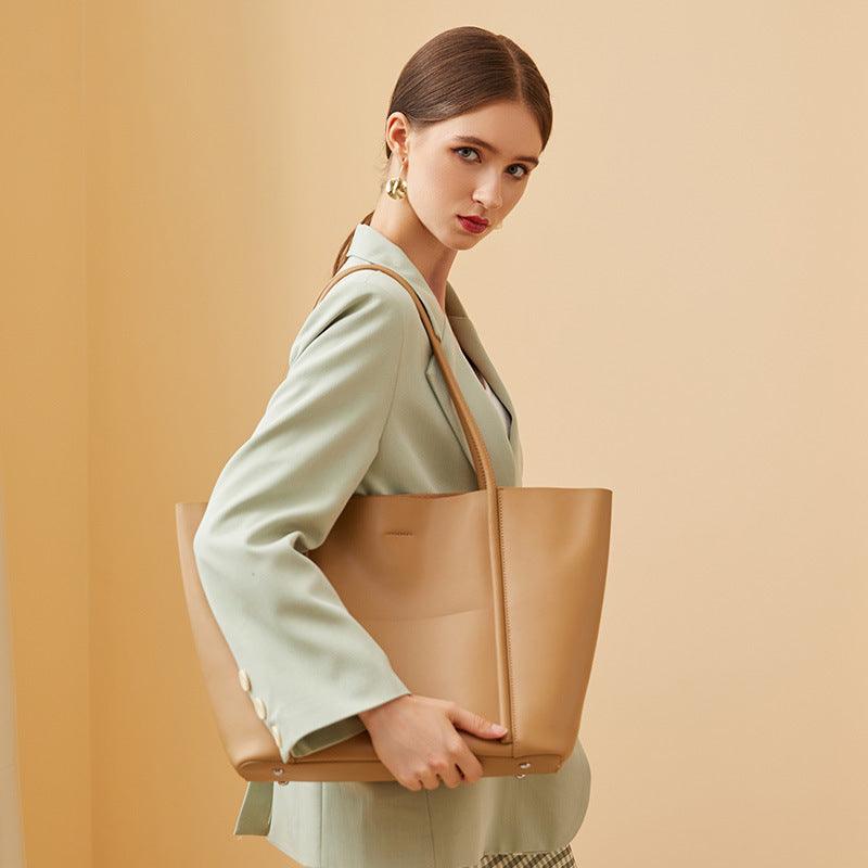 Woman in mint blazer carrying beige minimalist genuine leather tote handbag