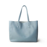 Minimalist light blue leather tote bag with double handles, classic shoulder style.