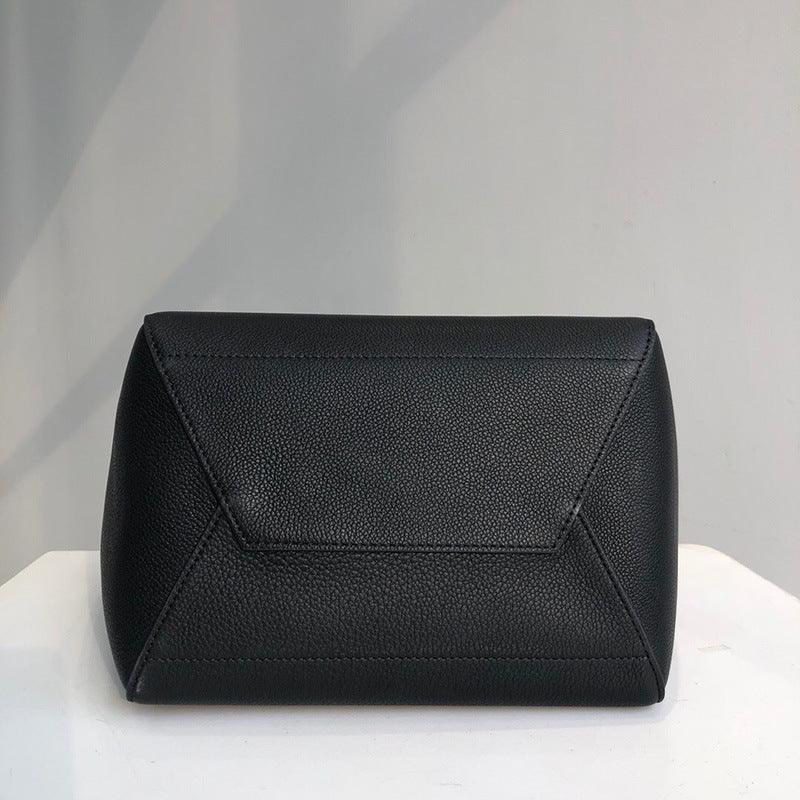 Black leather handbag with geometric stitching on a white surface
