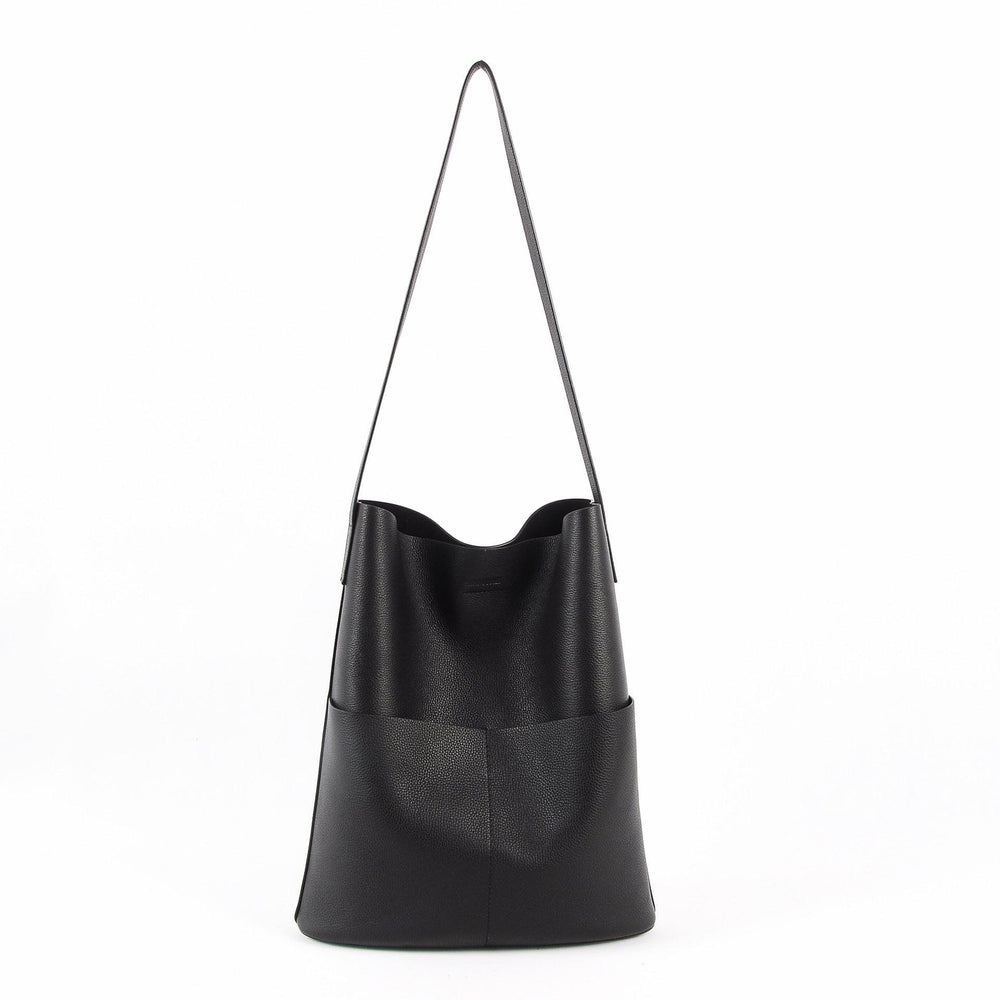 Black cowhide leather tote bag with two front pockets and long shoulder strap on white background