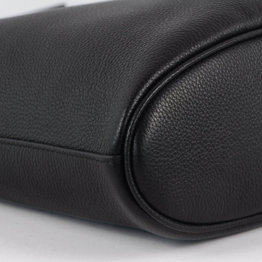Close-up of black pebbled leather handbag bottom with soft, rounded edges and smooth stitching